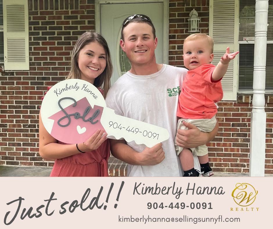 Kimberly Hanna with a young family holding a sold sign in front of their first home